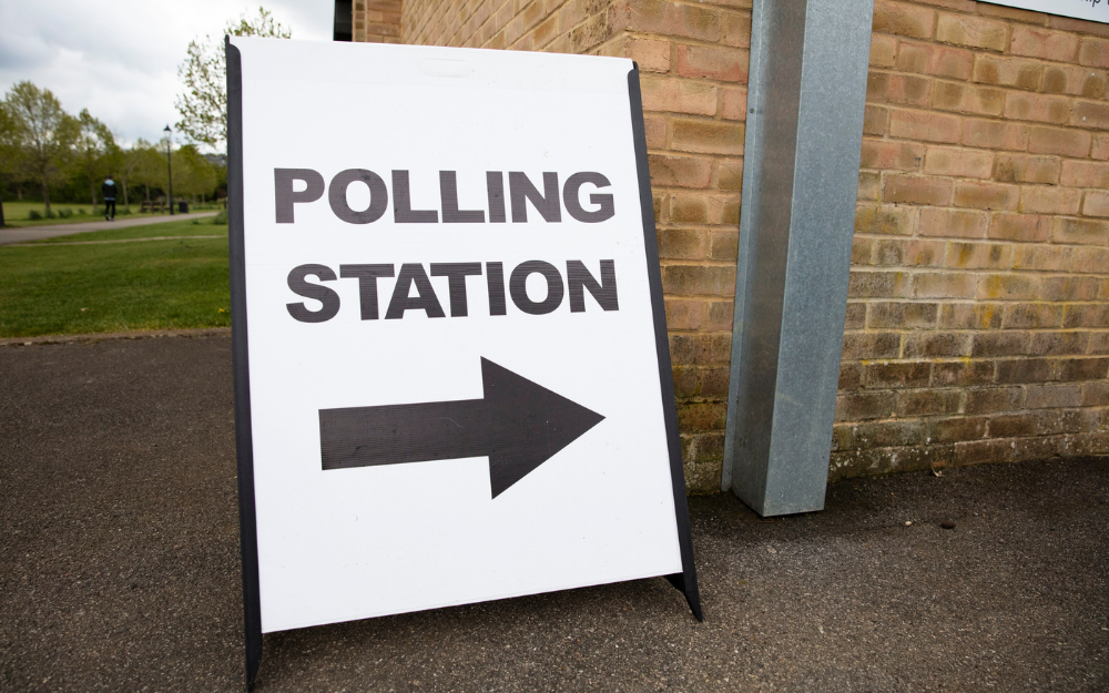 A polling station sign, pointing to the entrance