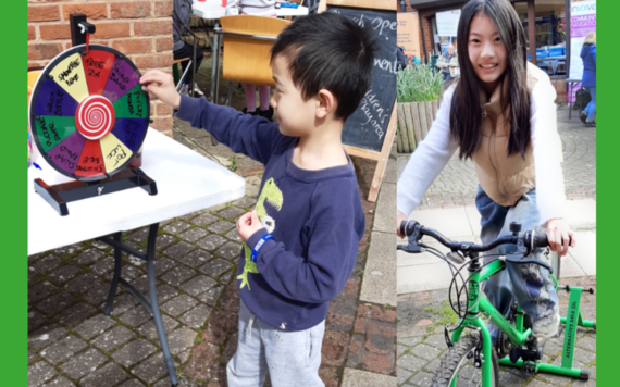 Two children one on the smoothie bike and the other having a go on spin the wheel