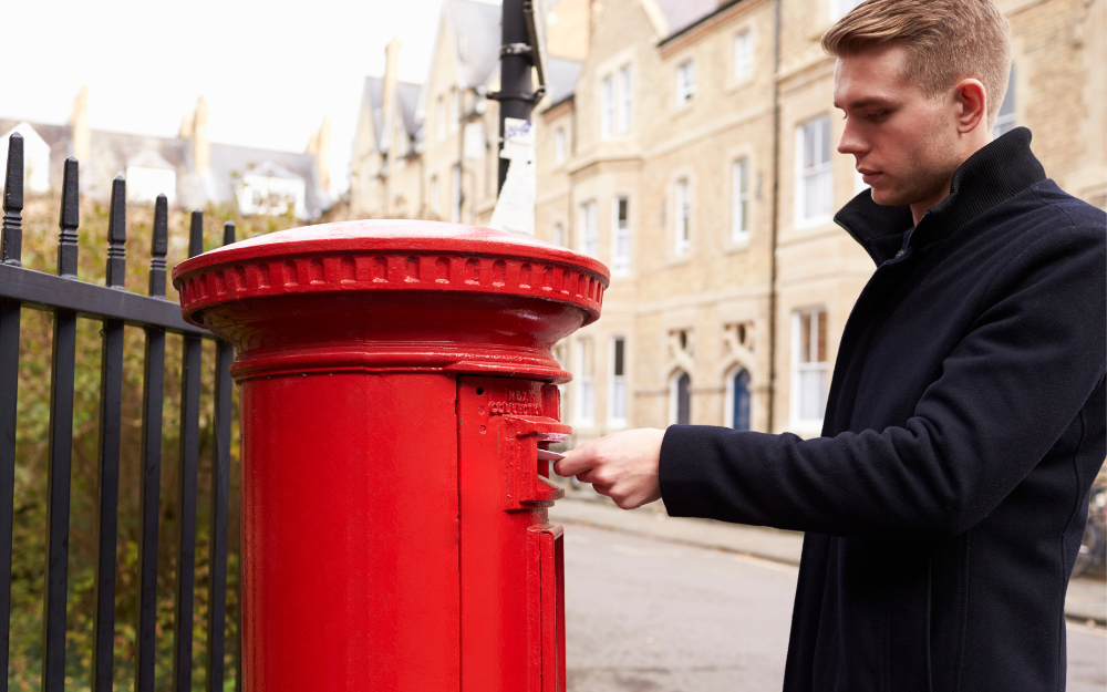 A man posting his postal vote into a post box