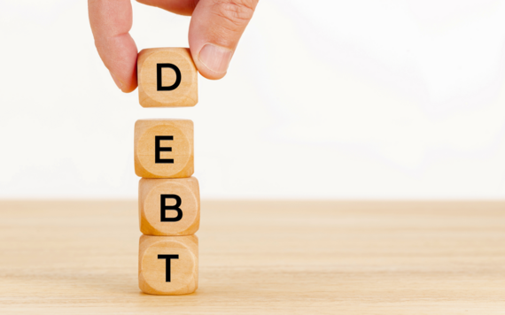 A stack of cubes spelling the word debt