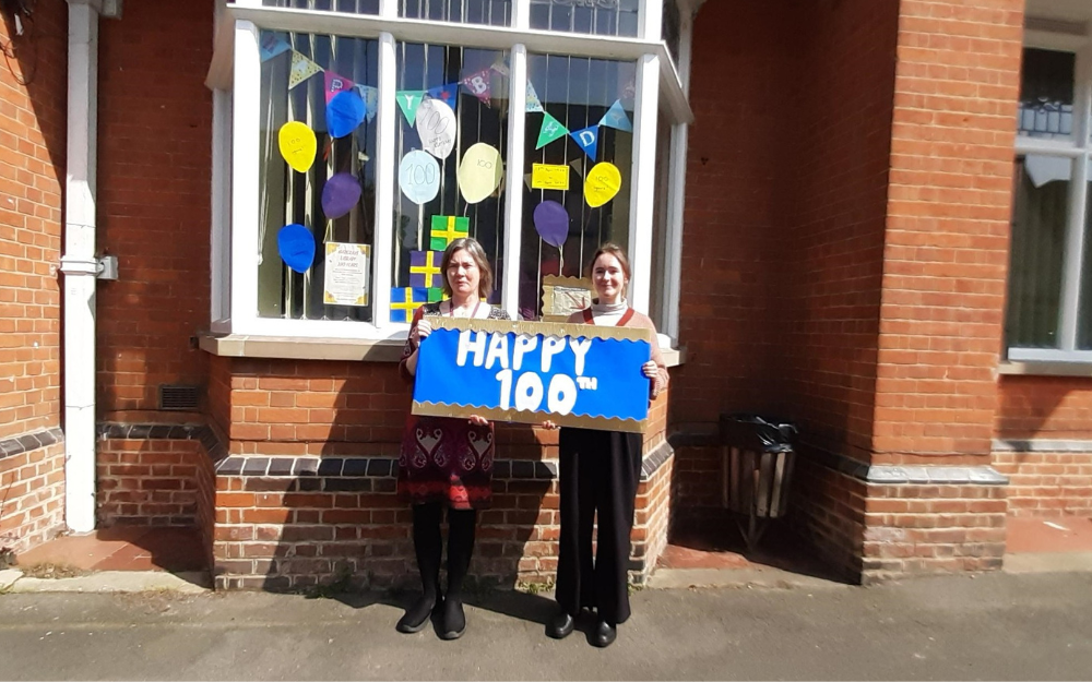 Library staff with a 100 sign outside Wargrave Library