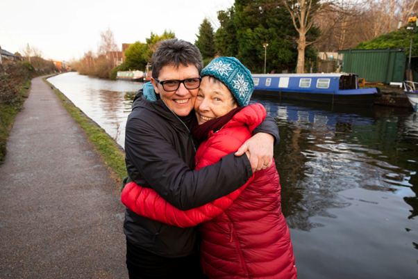 couple hugging on a cold day by a canal 