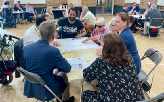 People talking around a table at a social care future event