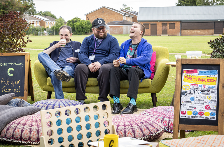 Three residents laughing on a sofa outside the Oakwood Centre at last year's Big Gathering