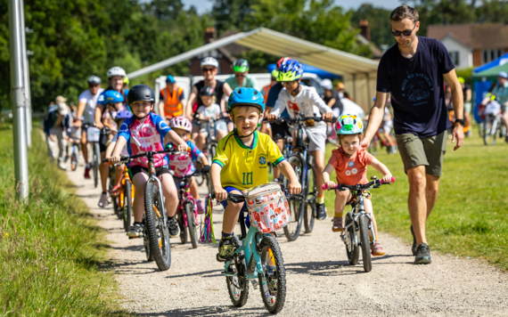 A group of children ride their bikes along a path