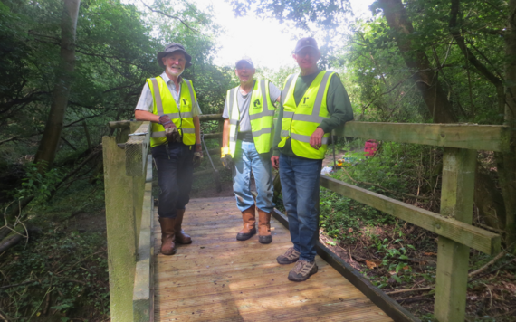 Loddon Valley Ramblers standing on a footbridge they have repaired