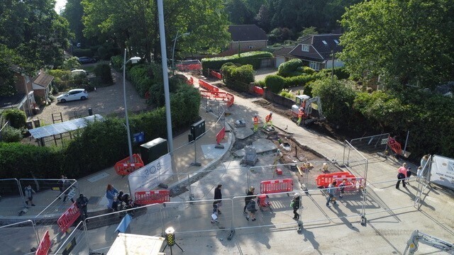 an aerial view of the ongoing improvement works at California Cross in Finchampstead, showing workers digging up the street