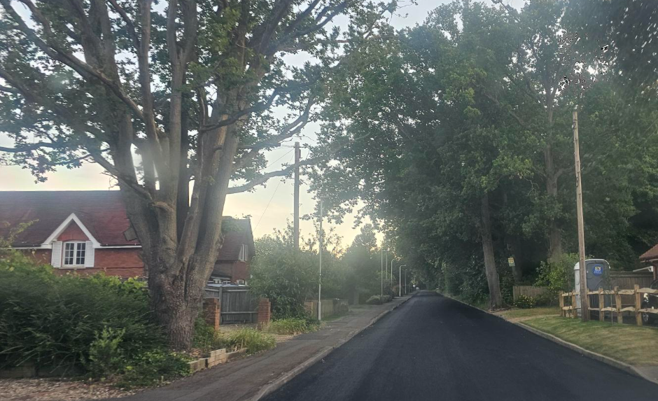 Shot of a smooth, black unlined road in a suburban area