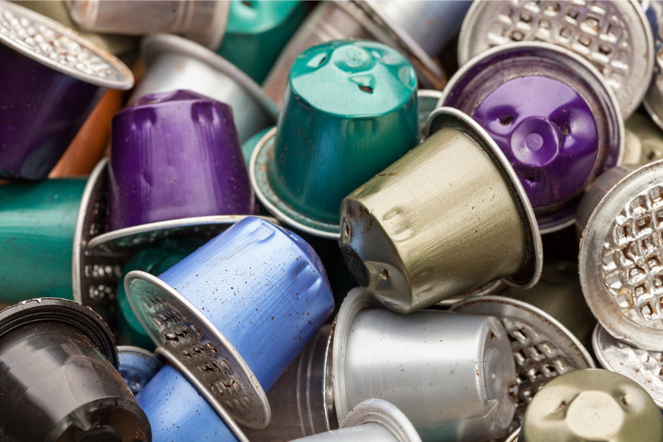 close up of a large pile of used metal coffee pods