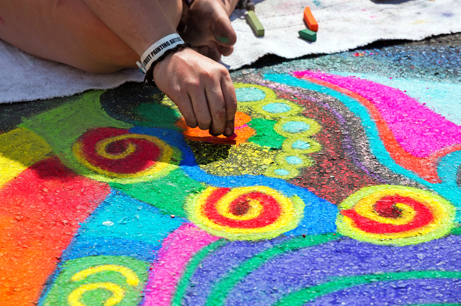 Colourful and bright chalk art being put onto a pavement