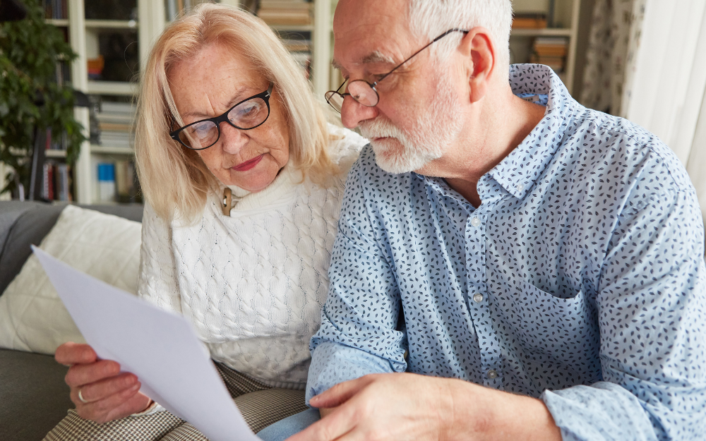 Two pensioners reviewing their finances on the sofa