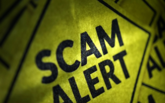 Yellow warning sign reading scam alert