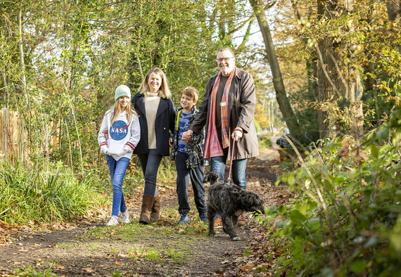 Family and their dog walking through some woods