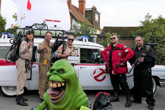 A group of people dressed as Ghostbusters standing in front of the Ghostbusters car at Shinfield