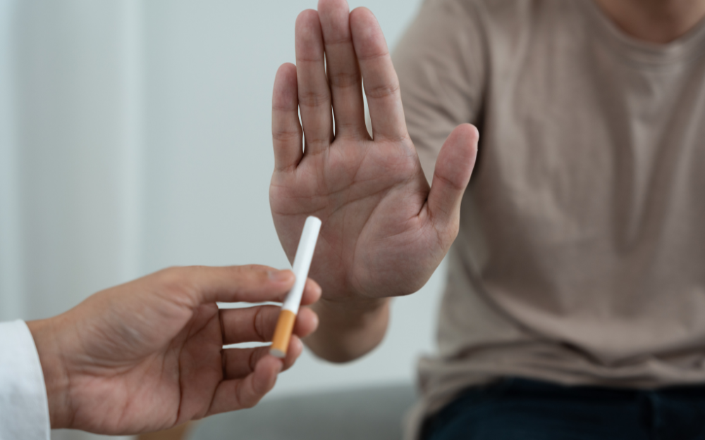 A person using their hand to refuse a cigarette they are being offered 