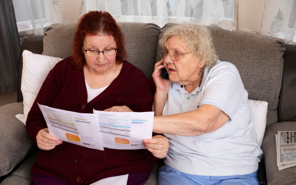 Two older women animatedly looking into details on a utility bill