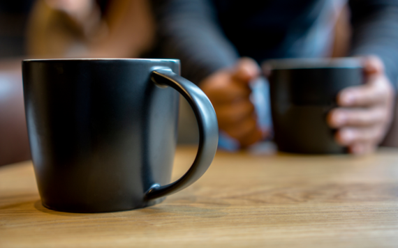 Two dark grey mugs on a table