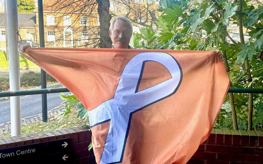 Councillor David Hare with the White Ribbon flag outside our Shute End offices