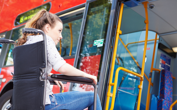 Young female in wheelchair boarding a bus