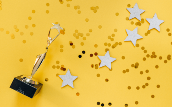 Trophy on a yellow background surrounded by stars