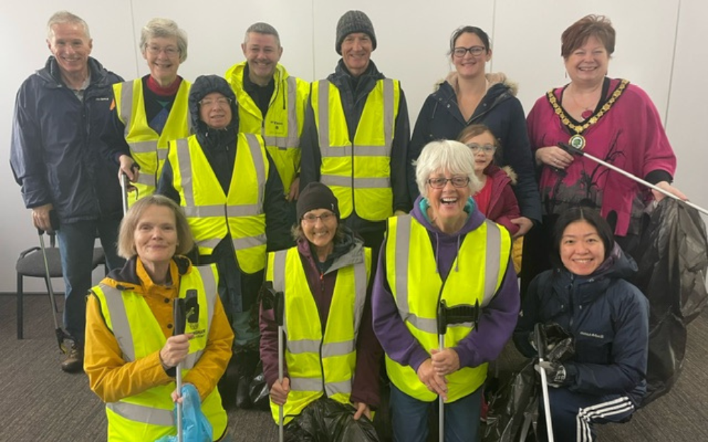Litter pick volunteers in Woodley hi-vis jackets and litter pickers