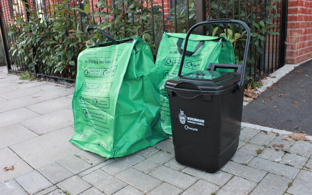 Green recycling bag and food waste caddy at the kerbside