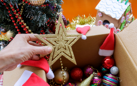 Christmas decorations including stars, baubles and santa hats being taken down a Christmas tree