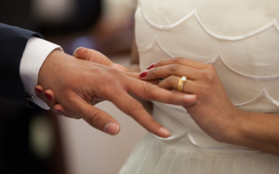 Close up of two rings being exchanged