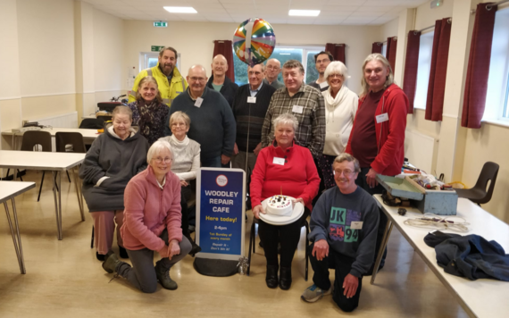 Volunteers posing for a group photo, with one of them holding a birthday cake