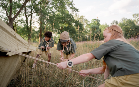 Children setting up a tent in countryside