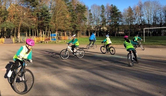 children riding bicycles around a course outdoors