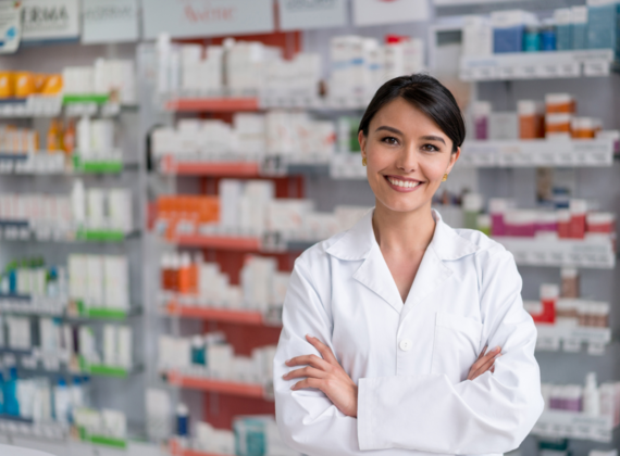 Female pharmacist in front of shelves of medicines at a pharmacy counter