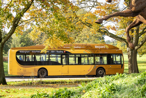 The leopard 3 bus passing through beautiful countryside with grass and trees at the roadside