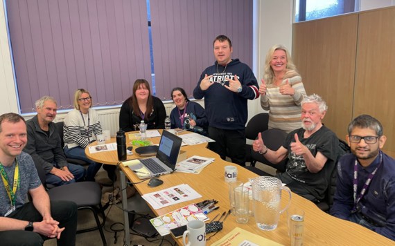 A group of men and women at Optalis offices looking at examples of symbols and pictures