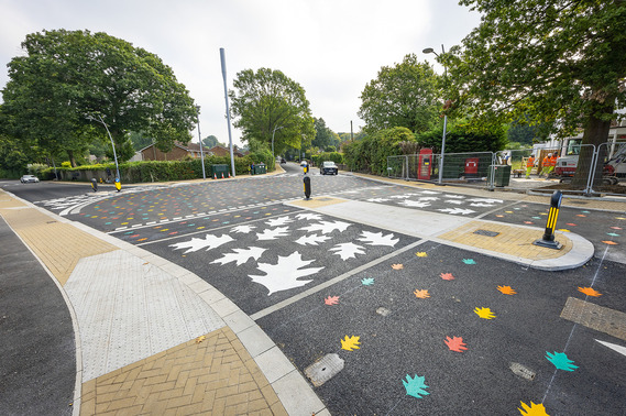 shot of a new road junction at California Cross where the pavement is level with the road and the road is covered in multi-coloured leaf patterns