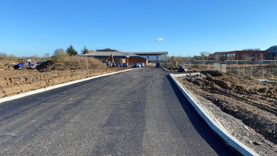 Shot of a newly built access track leading to a vacant supermarket building on an unfinished building site