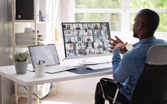 Man sat at desk involved in an online meeting