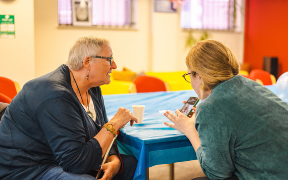 Lady showing another lady something on a mobile phone