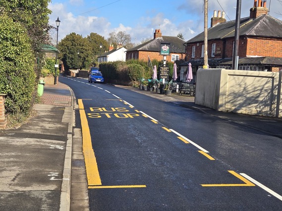 a newly resurfaced stretch of road outside the Crown pub and bus stop in Swallowfield