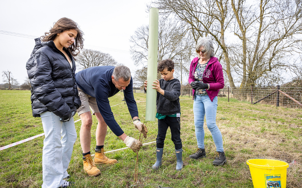 A family plant a tree at the Covid-19 memorial woodland planting sessions