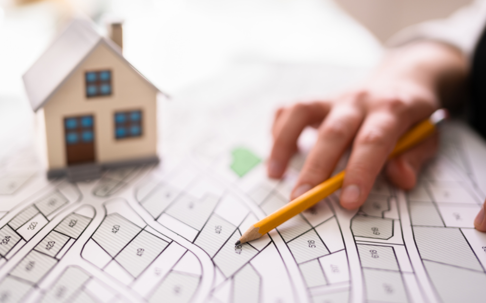 A pencil and house while a map is marked up with locations
