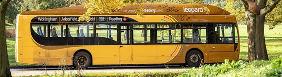 side view of the leopard 3 bus passing through a wooded area