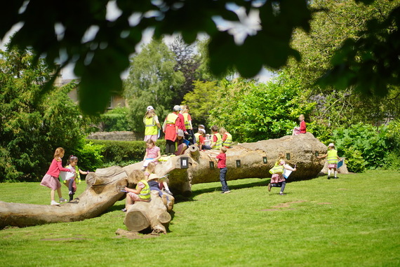 a group of children playing and having fun on a large climbable log