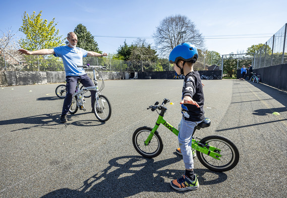 Cycle instructor teaching child to cycle