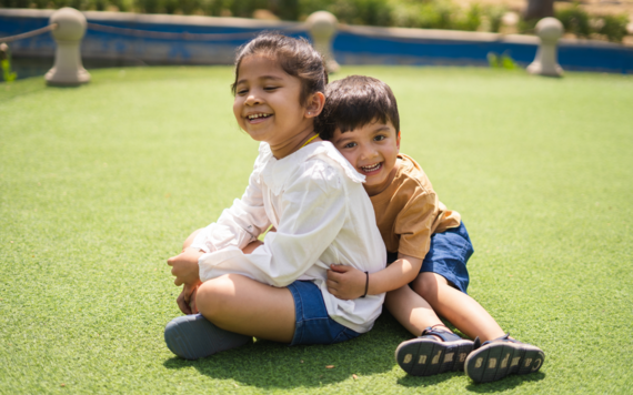Two siblings smiling and hugging