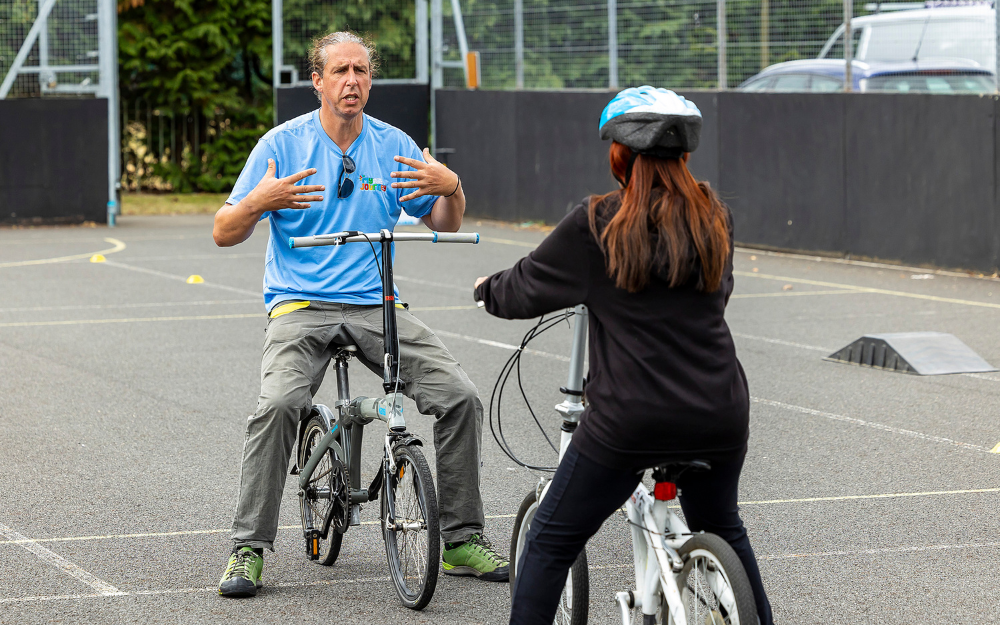Man teaches an adult about riding a bike