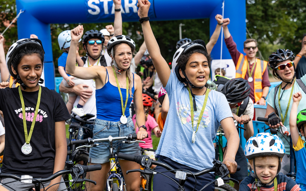 People on bicycles in helmets cheers at the start of Wokingham Bikeathon