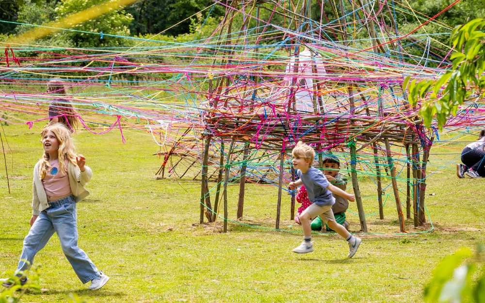 Children playing in woven art installations at Dinton Pastures for Forest of Imagination