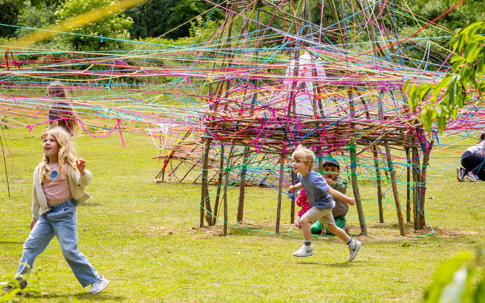 Children playing underneath the woven creation at Forest of Imagination