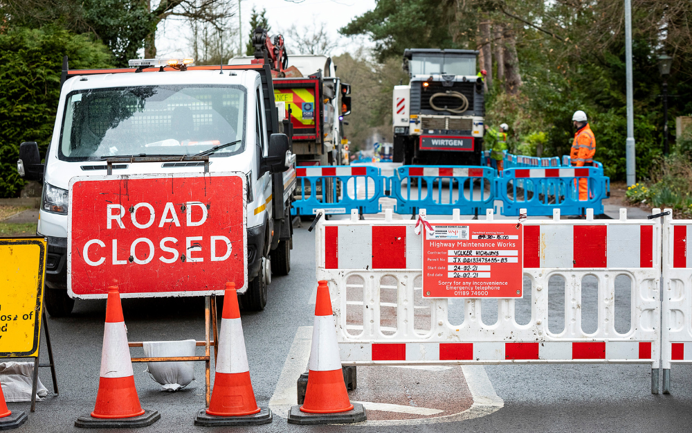 road closed sign on road with work taking place in background